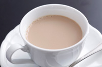 白いカップに薄茶色の飲み物が淹れられている写真