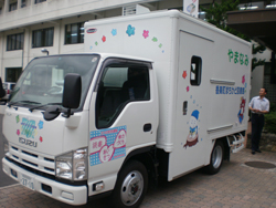 花模様やイラストのプリントがされた白いトラック車の写真