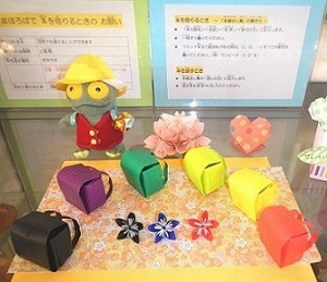 キャラクターのぬいぐるみと小さなランドセルの小物や花の小物が机に並べられている写真