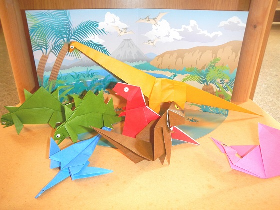 様々な恐竜の形に折られた折り紙がテーブルに置かれている写真