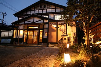 玄関の前に植えられた木の根元に明かりが設置されている写真