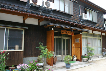 2階の窓に室外機が複数設置されている木造建築の写真