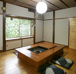 囲炉裏のついたテーブルが設置された部屋の写真