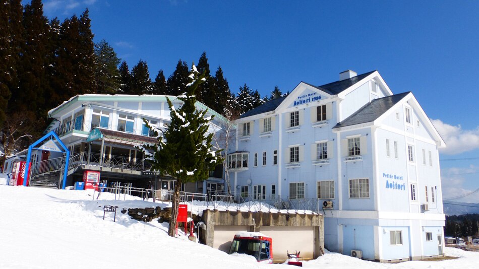 あたりに雪が積もっている白い建物の写真