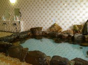 岩に囲まれたタイル張りの浴槽の写真