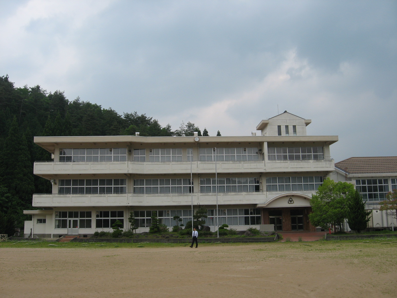 白い壁の建物の側にグラウンドがある写真