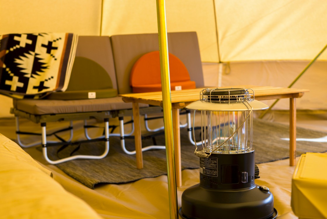 テーブルや椅子が置かれた部屋にランタンが置かれている写真