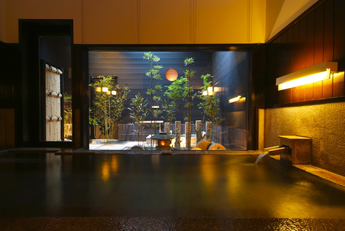 中庭の庭園が見える温泉の写真