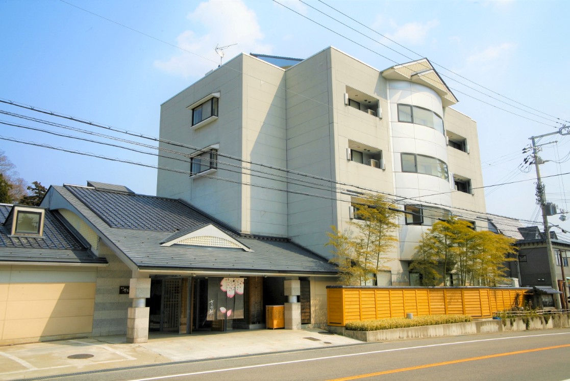 三角の屋根をした建物と4階建て建物が並んでいる写真