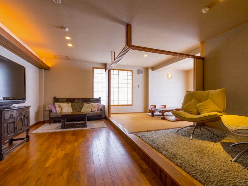 ソファなどが置かれている木目のフローリングの部屋の写真