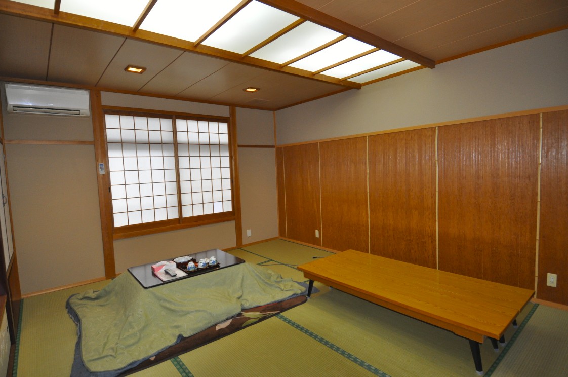 エアコンやミニテーブルが設置されている和室の写真
