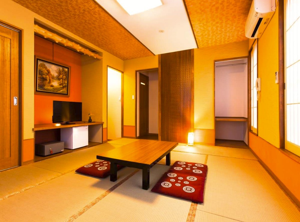 丸の模様が書かれた赤い座布団とミニテーブルが置かれた和室の写真