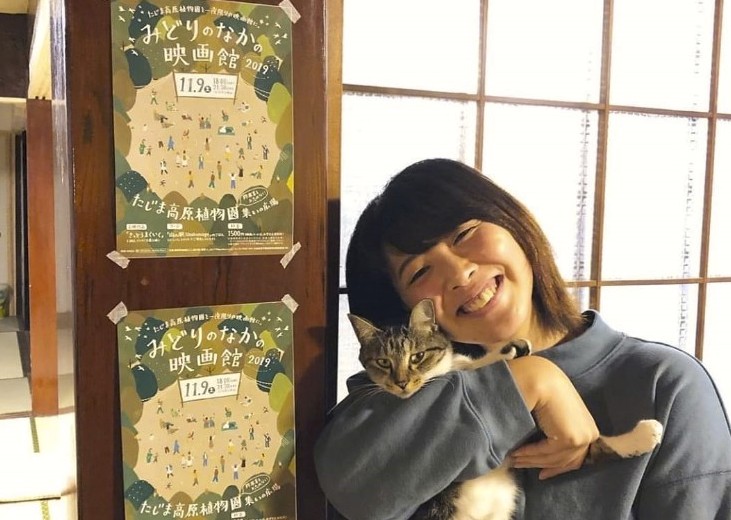 猫を抱いて笑っている女性の写真