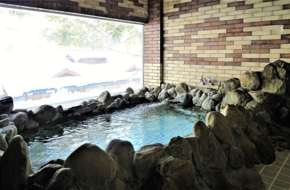 ゴツゴツとした岩に囲まれた温泉の写真