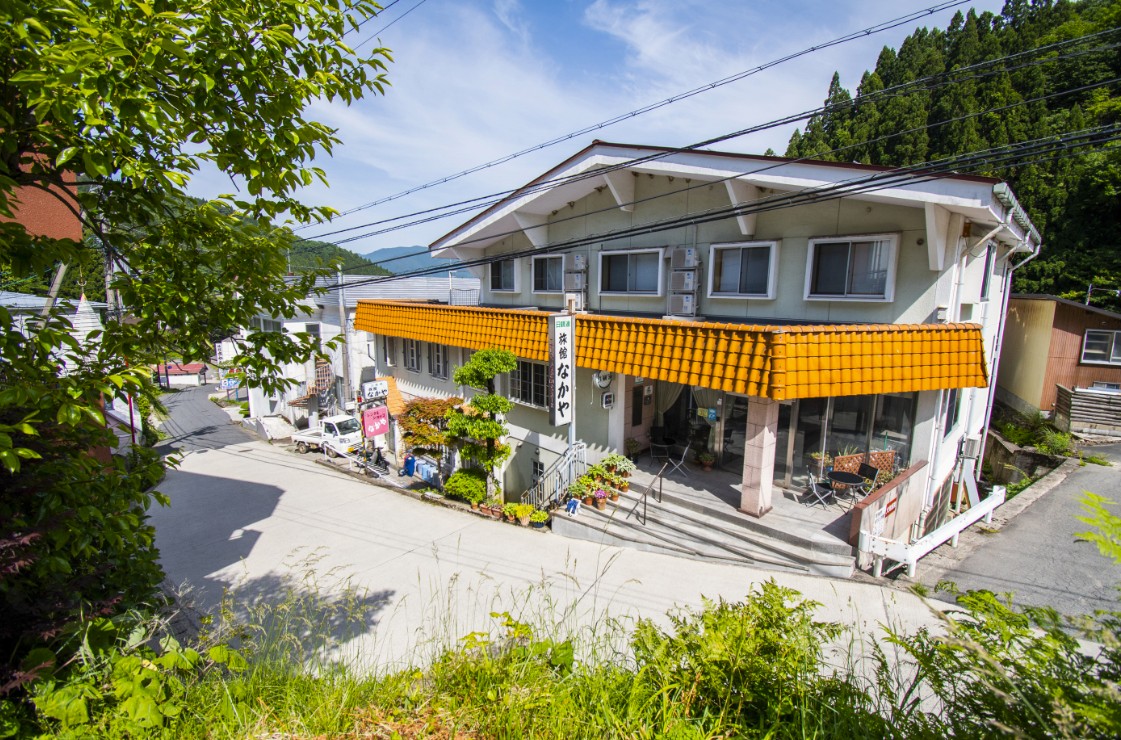 オレンジ色のベランダが付いている白い建物の写真