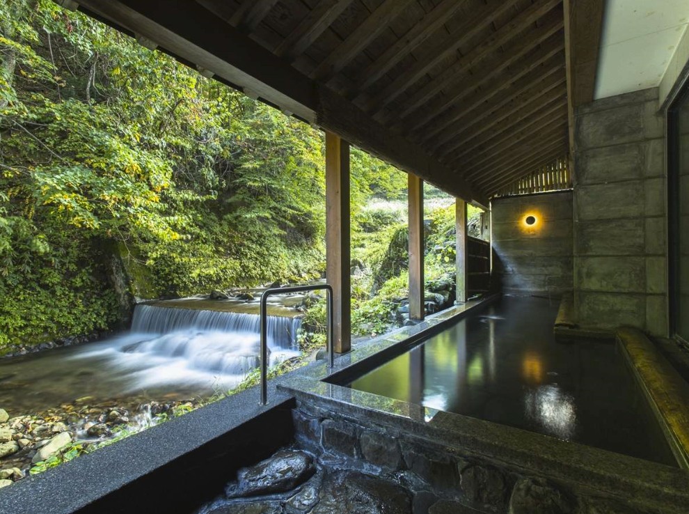 川や木が見える露天風呂の写真
