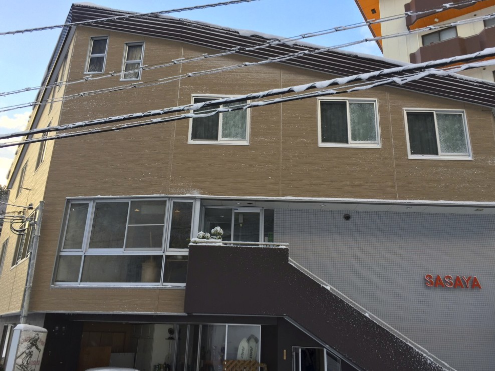 茶色の壁をした建物に「SASAYA」の文字が飾られている写真