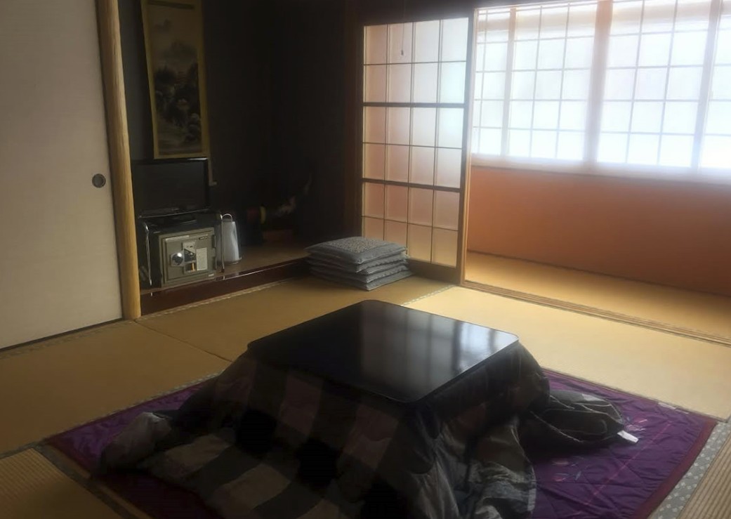 白と黒のチェック模様をした布団がかかったこたつのある和室の写真