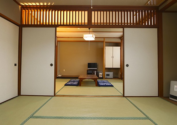 襖の向こうに座布団やテーブルが置かれている和室の写真