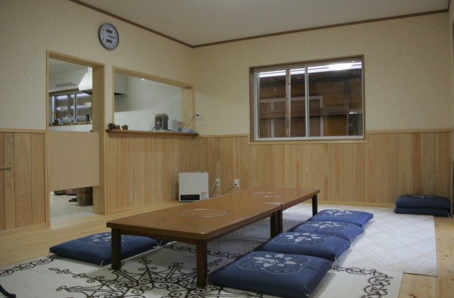 背の低いテーブルと青い座布団が置かれた部屋の写真