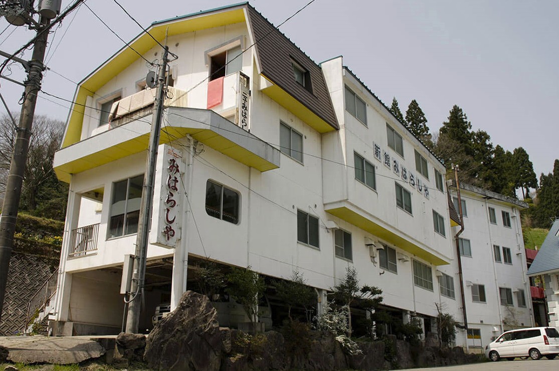 「みはらしや」と書かれた看板が掛けられている白い建物の写真