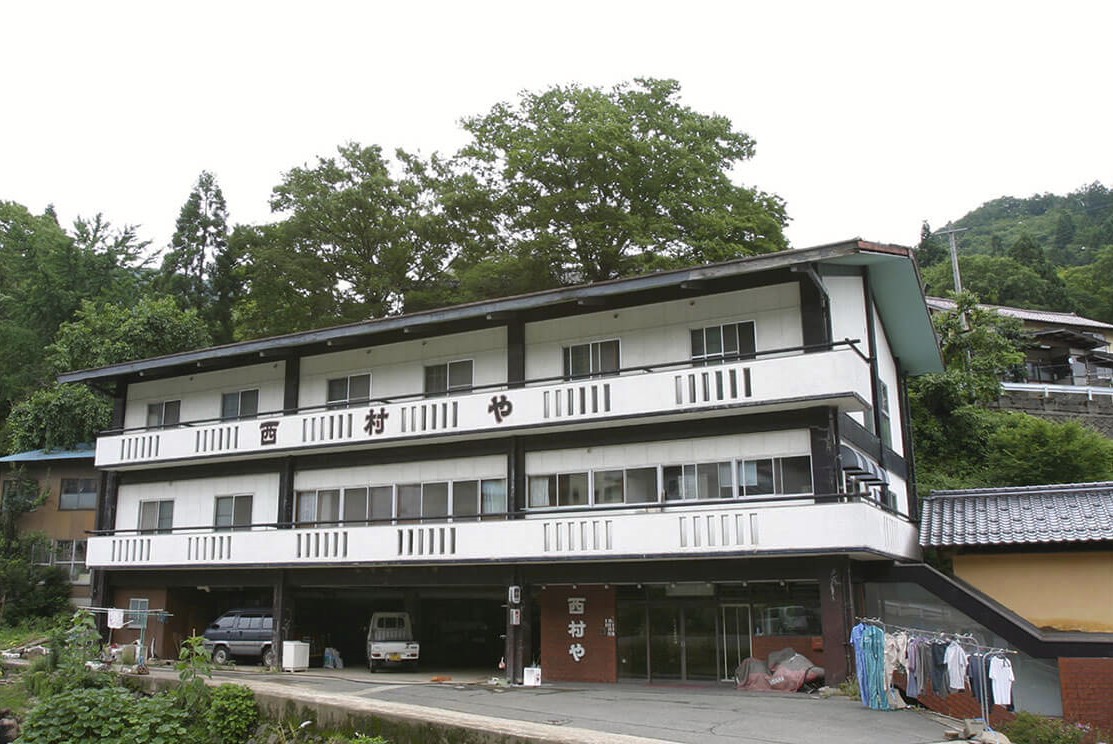 「西村や」と書かれた白い建物の写真