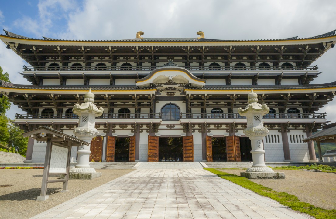 石畳の道の先にある寺の本堂の写真