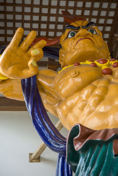 黄色い体で筋肉のある仁王像を下から見上げた写真