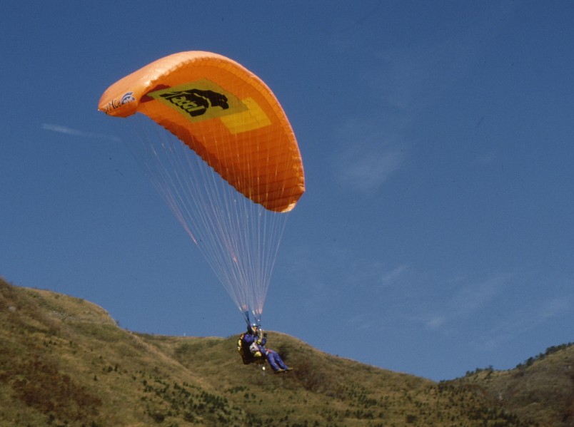 パラグライダーを広げて滑空している人の写真