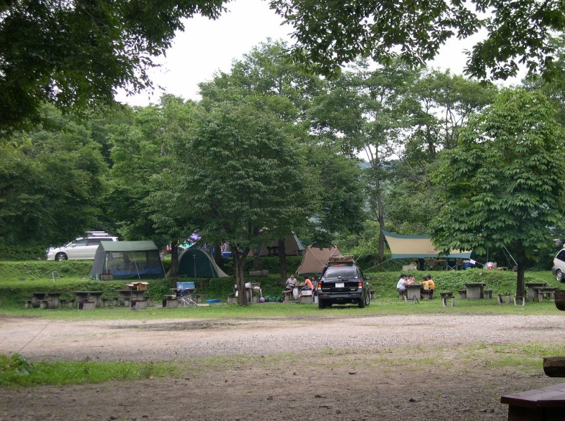 木製のテーブルがいくつも並んでいる広場の写真