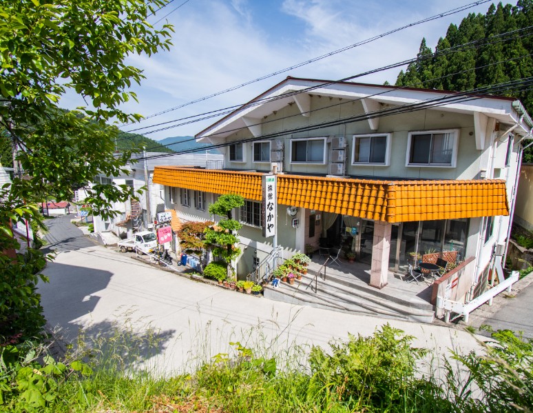 オレンジ色のベランダが付いた2階建て建物の写真