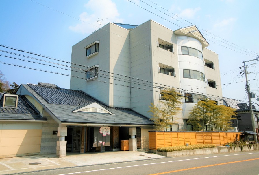 斜めになった屋根の建物と白い壁の建物が1つになっている写真