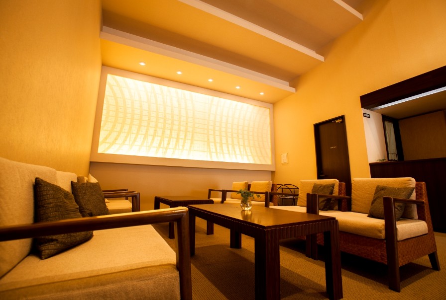 淡い明りに照らされた部屋にイスやテーブルが並んでいる写真