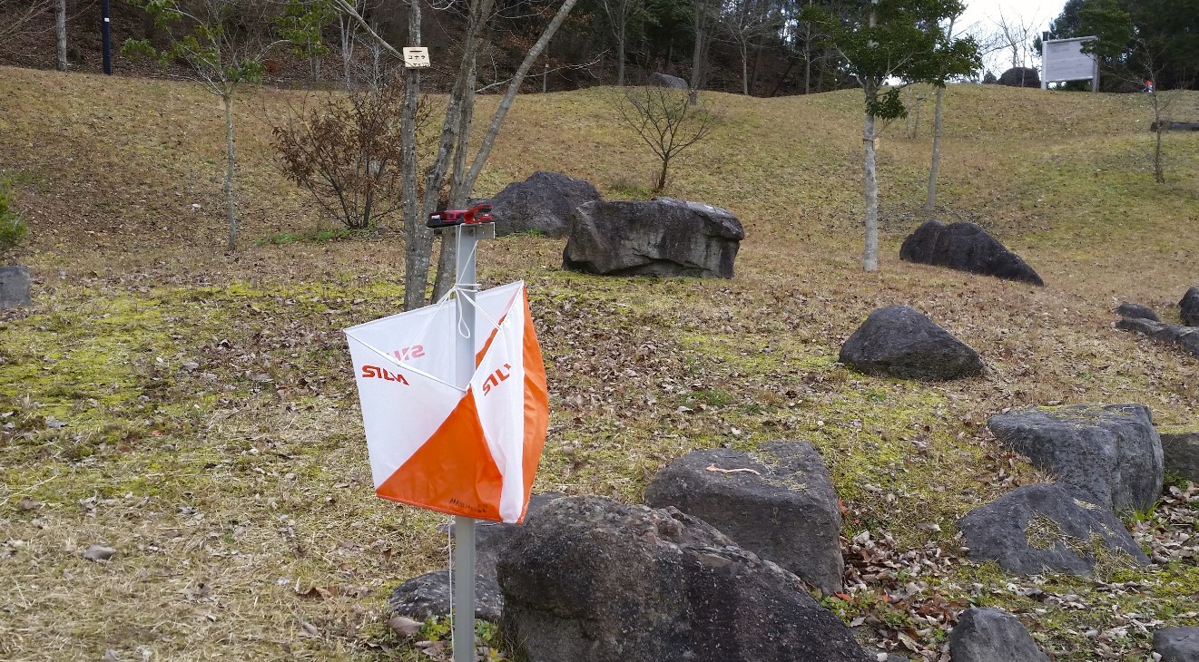 支柱につけられたオレンジと白のフラッグの写真