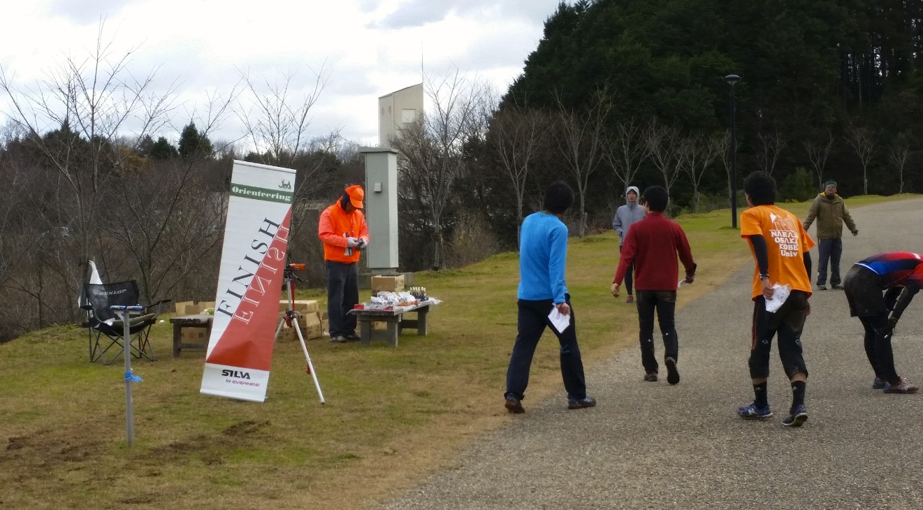 道路わきで準備をするサポーターと周辺に集まるランナーたちの写真