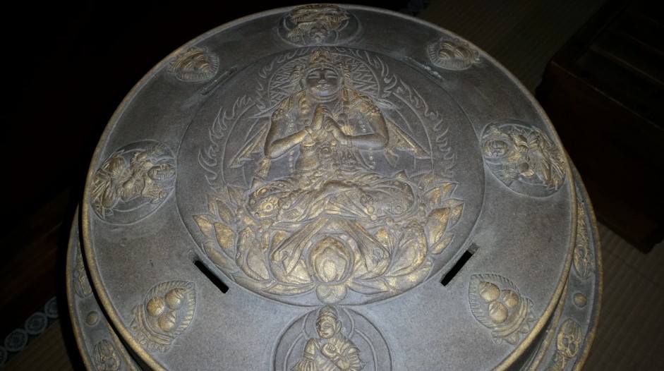 仏が複数彫られた円形の器物の写真