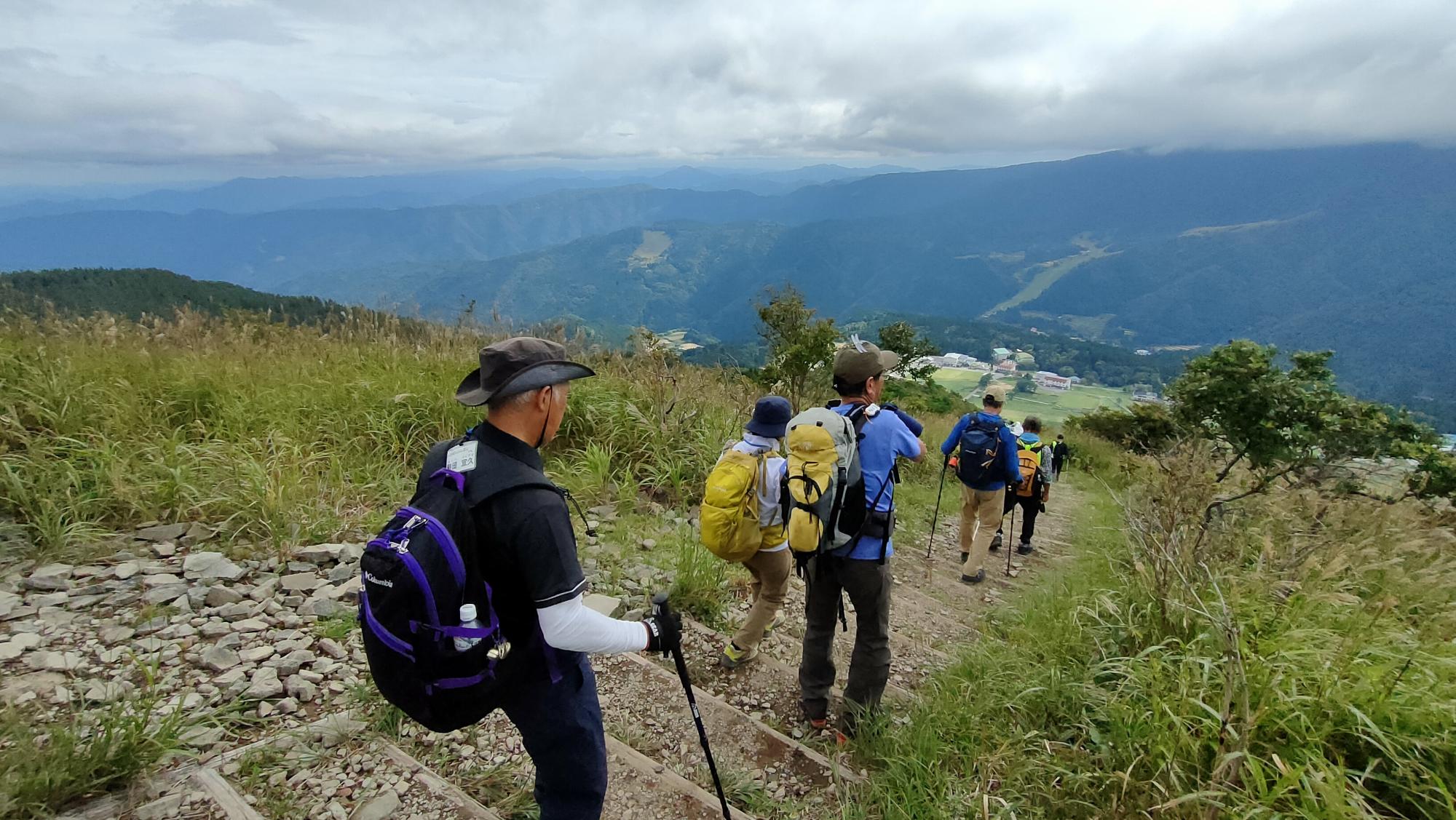 登山道の階段を下っている登山客の写真