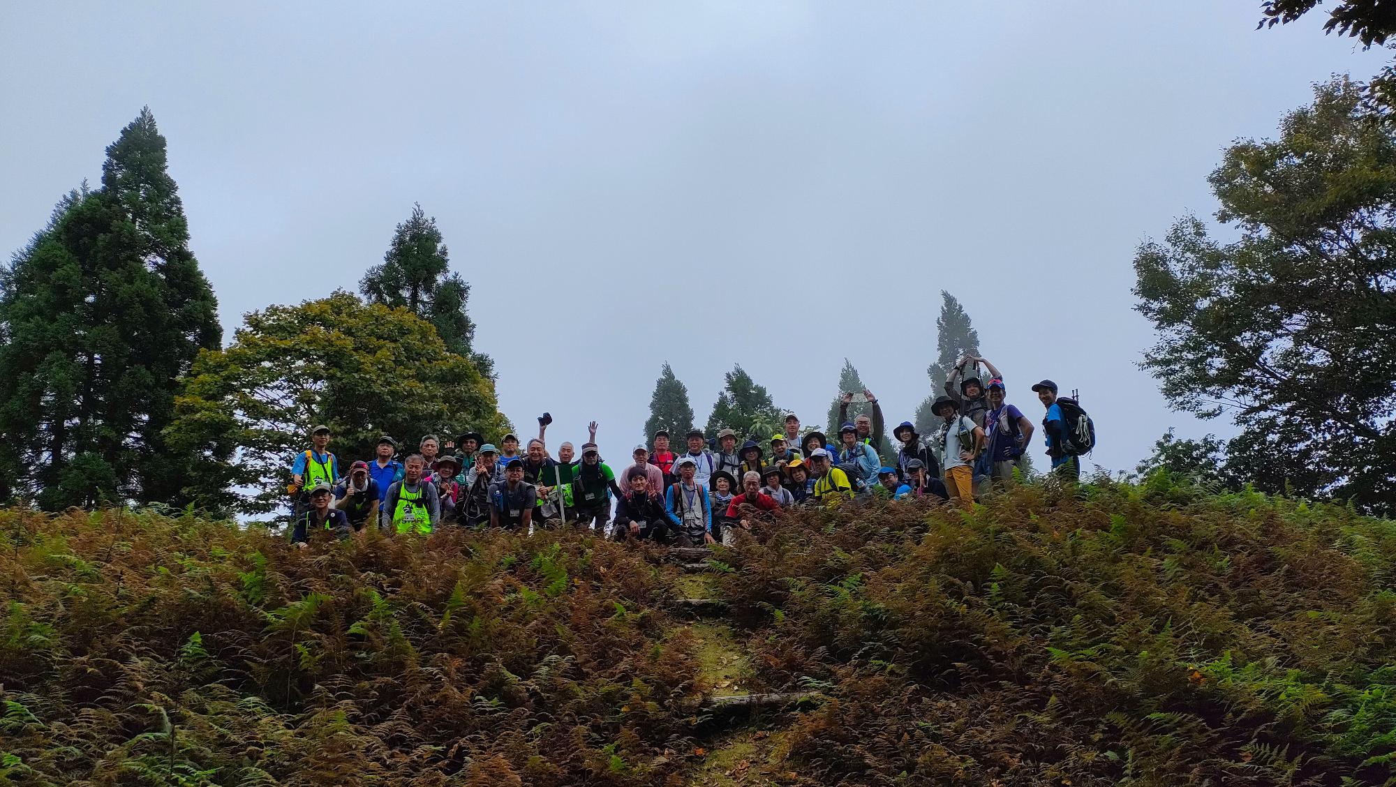 山頂に並んでいる人たちを引きで写した集合写真