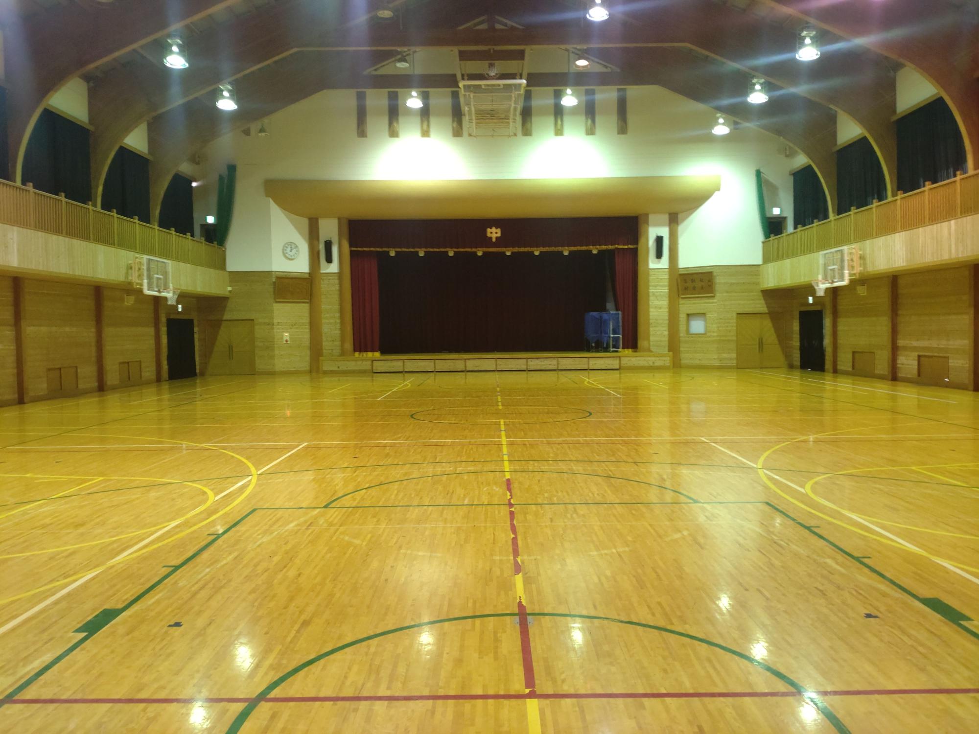 場内が照明で照らされている体育館の写真