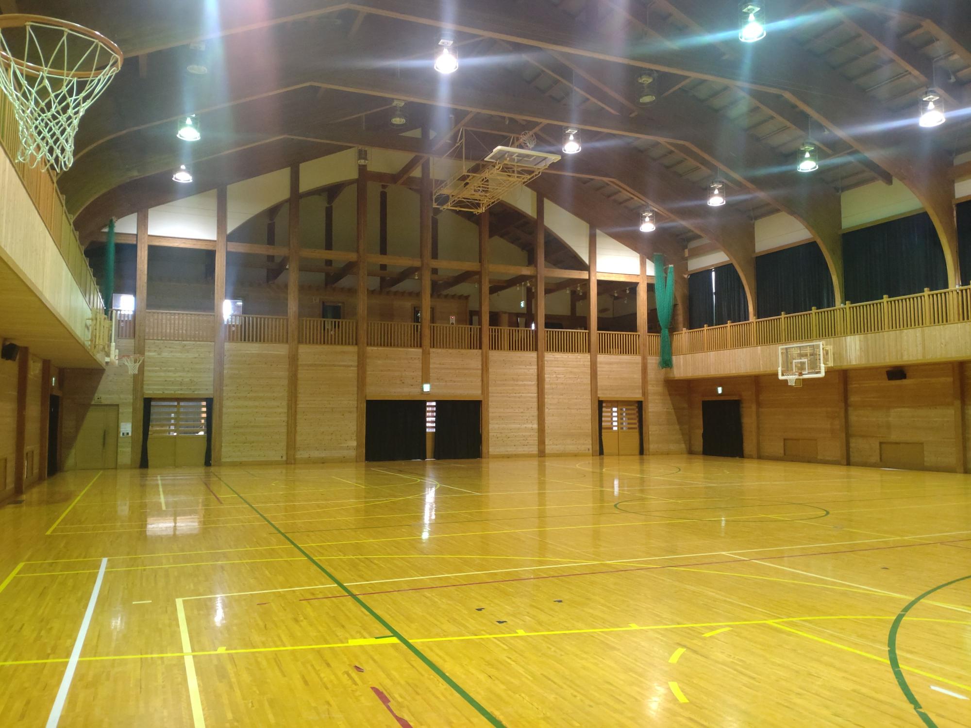 場内が照明で照らされている体育館の入り口側の写真