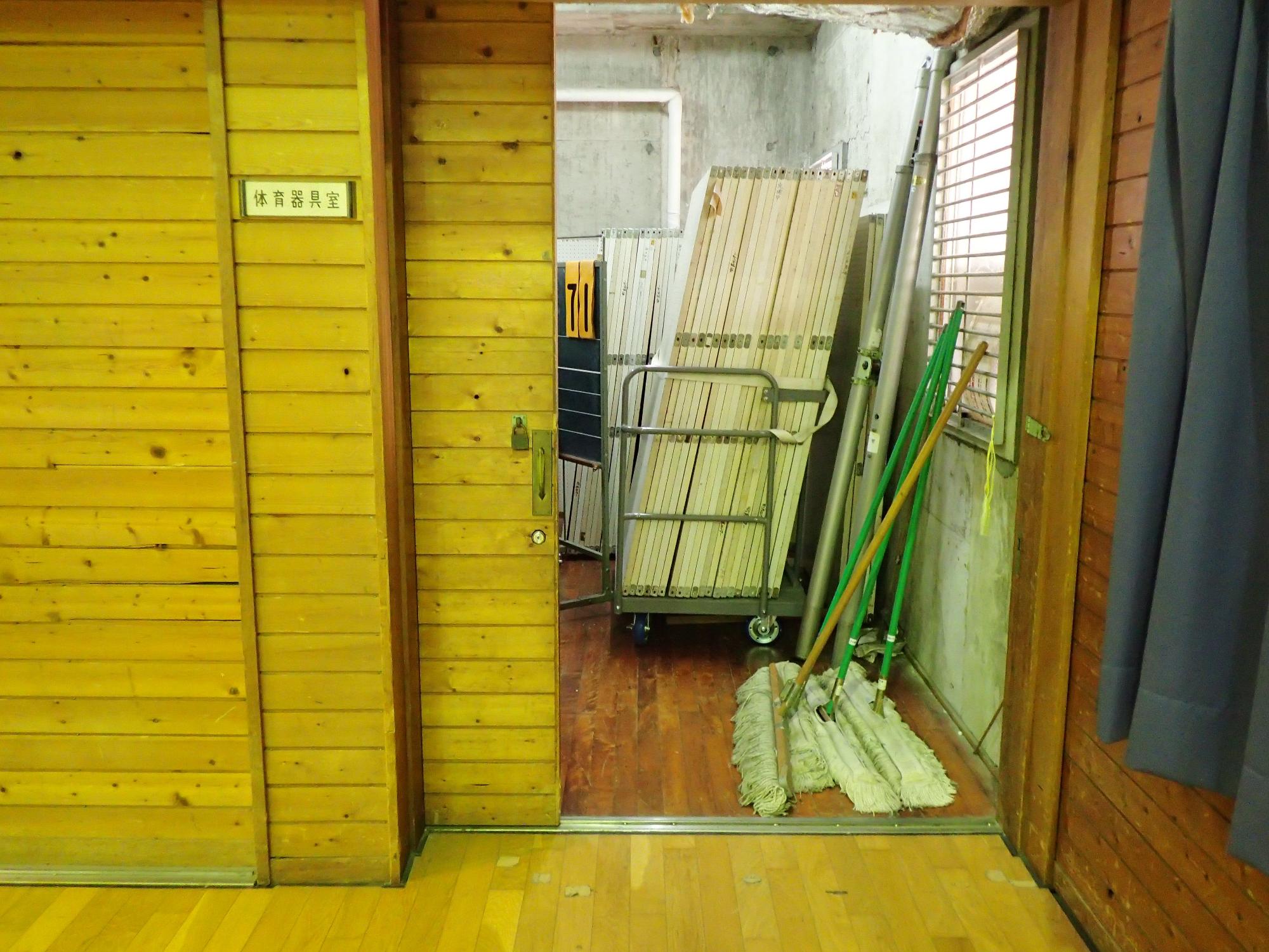 掃除用具や器具が置かれた部屋の扉が開かれた入口写真