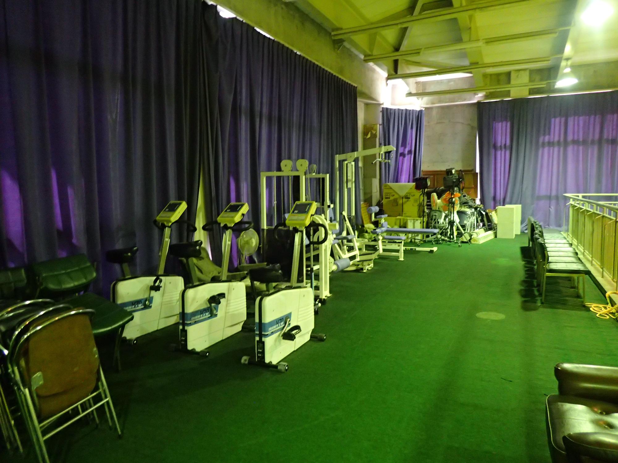 カーテンの閉まった部屋に運動用の器具がいくつか置かれた写真