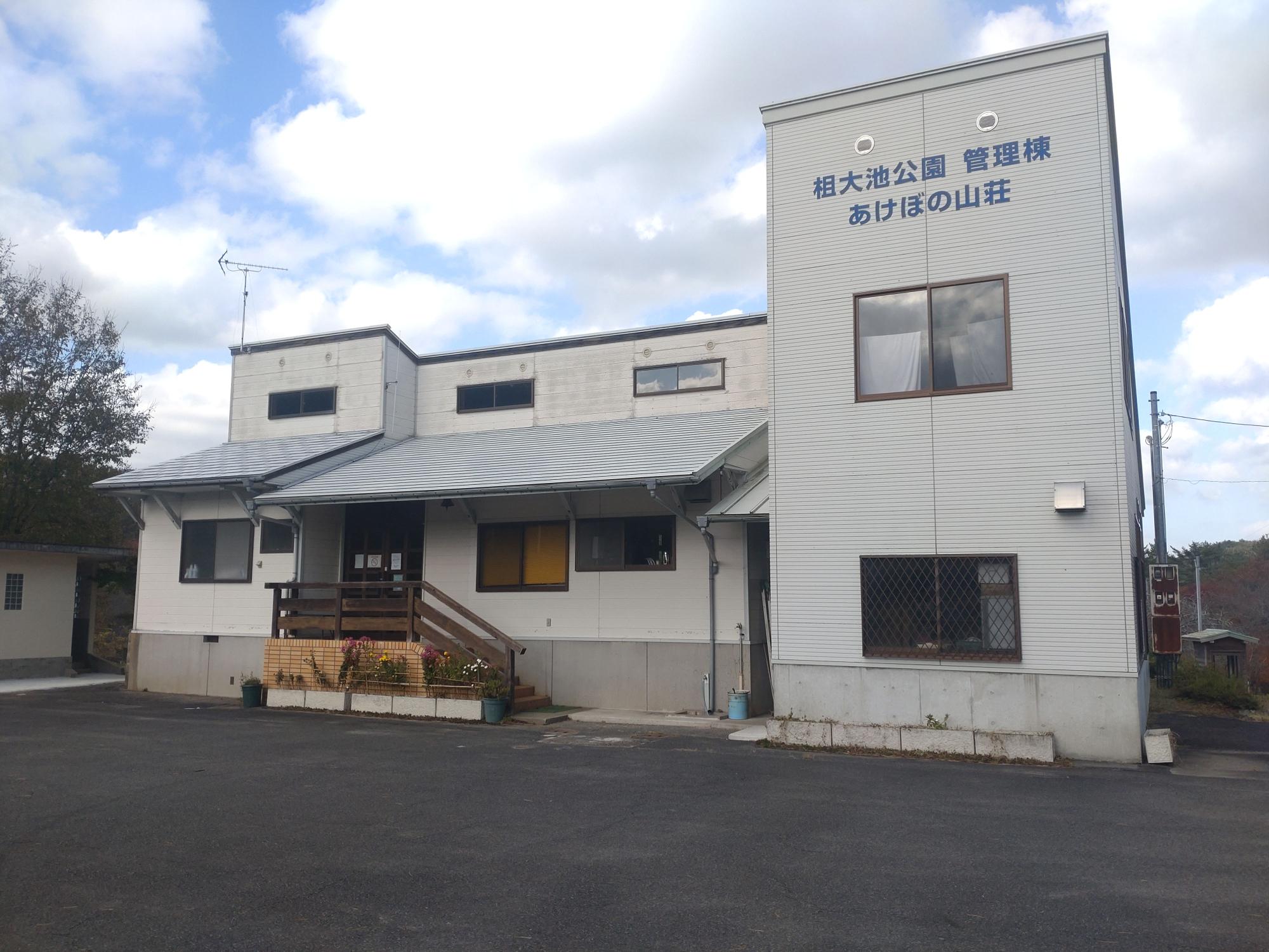 灰色の壁にあけぼの山荘と書かれた二階建ての建物の写真