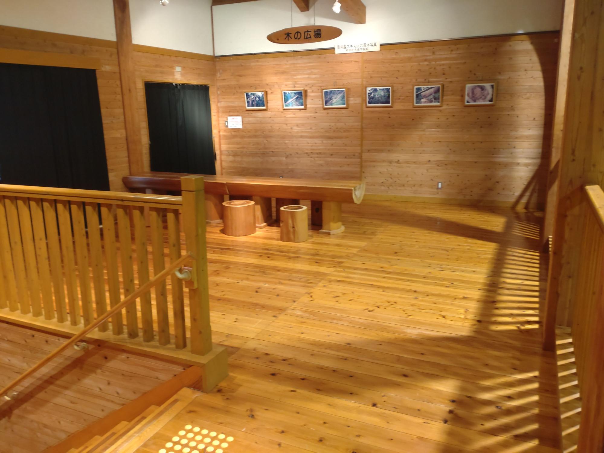 奥にテーブルとイスが設置されている木製の室内の写真