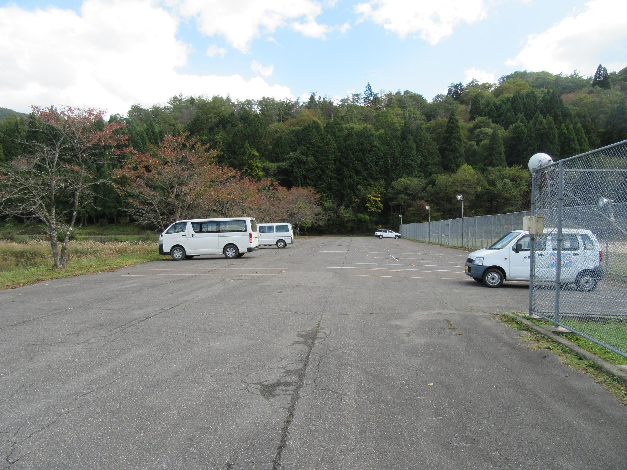 広い道路の脇に複数台の車が停まっている写真