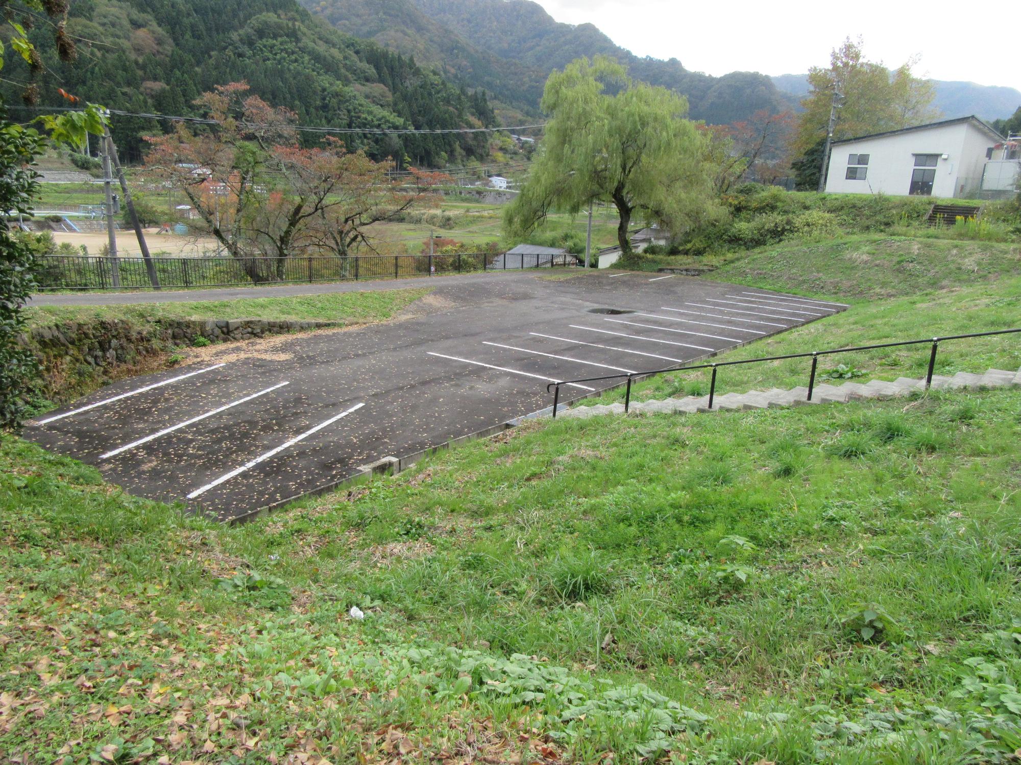 周りが草地の中に長方形の形にスペースがとられた駐車場の写真
