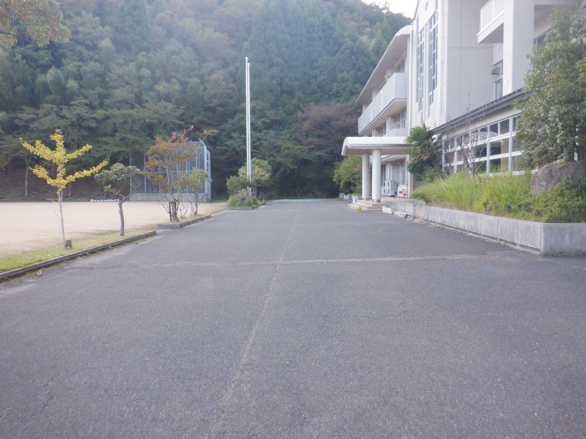 建物とグラウンドの間にあるアスファルトの空間の写真