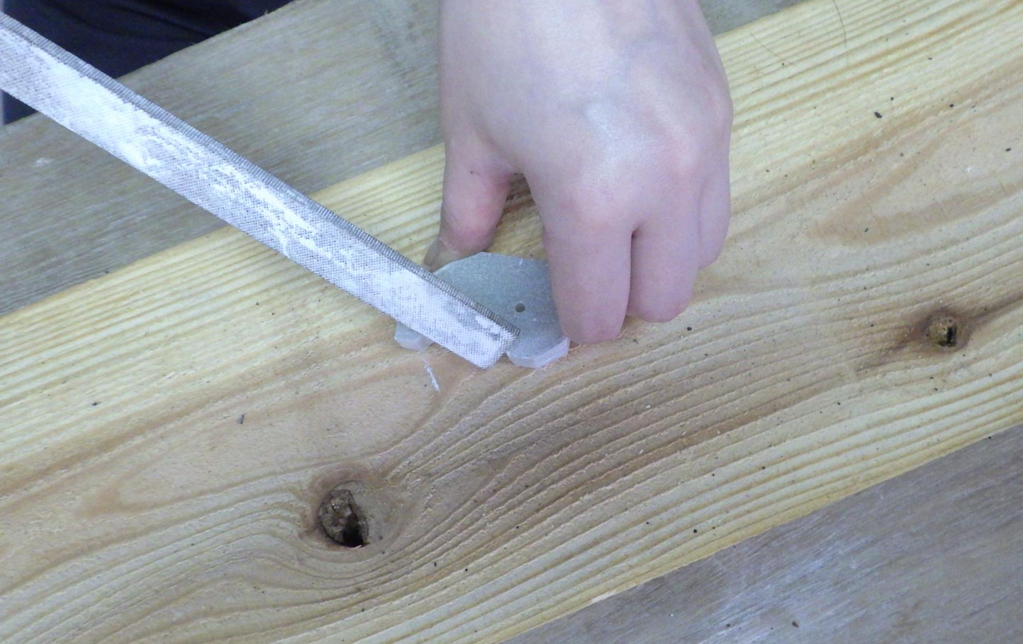 白い石の角をやする人の手元の写真