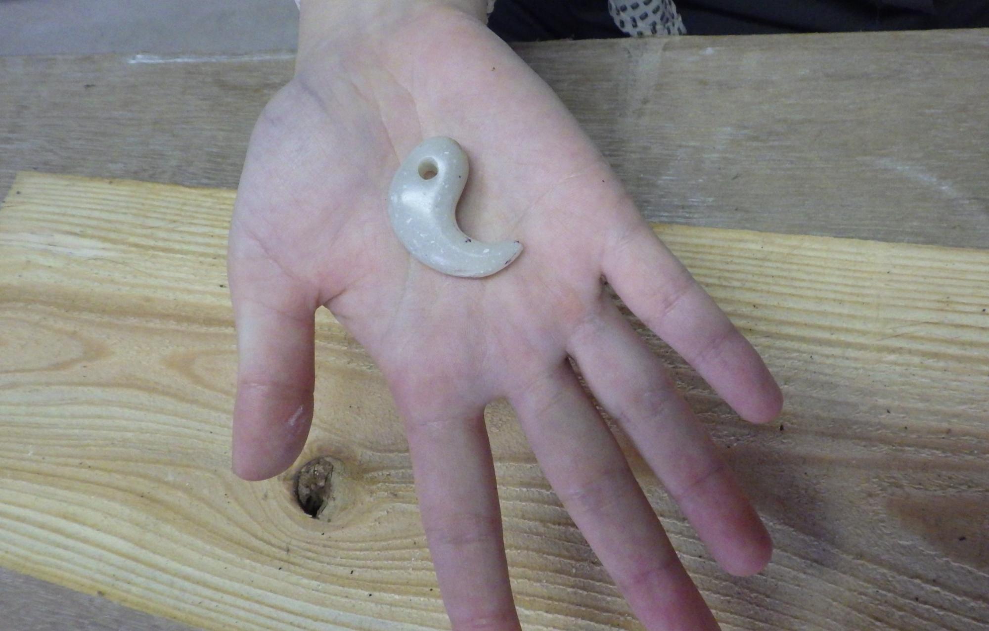 勾玉を手のひらに乗せて見せている人の手元の写真