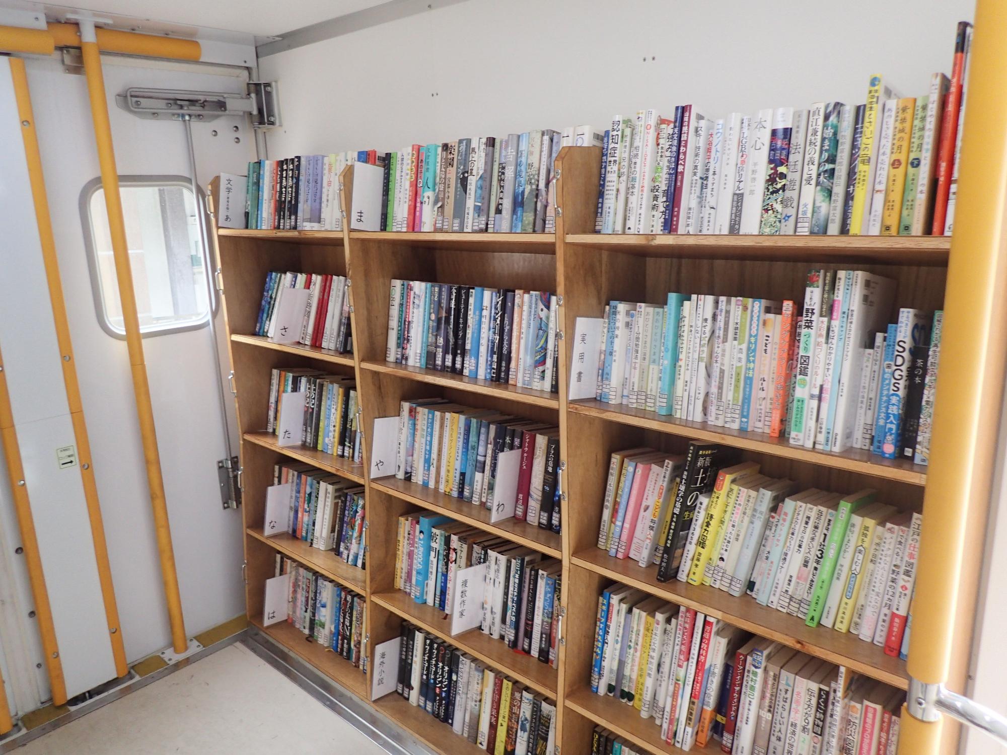 扉の傍に設置された木製の本棚の写真